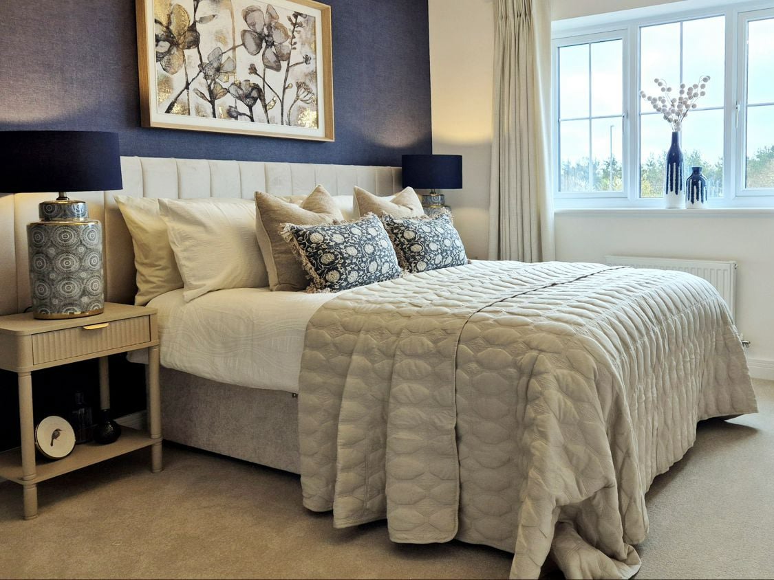 show home master bedroom in neutrals and dusky blue